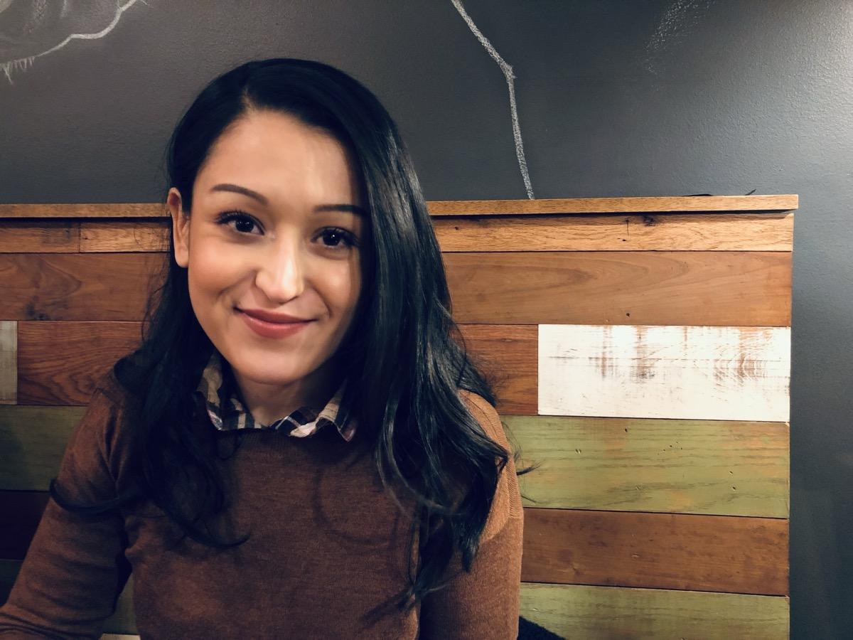 Original image of a smiling woman wearing a brown sweater